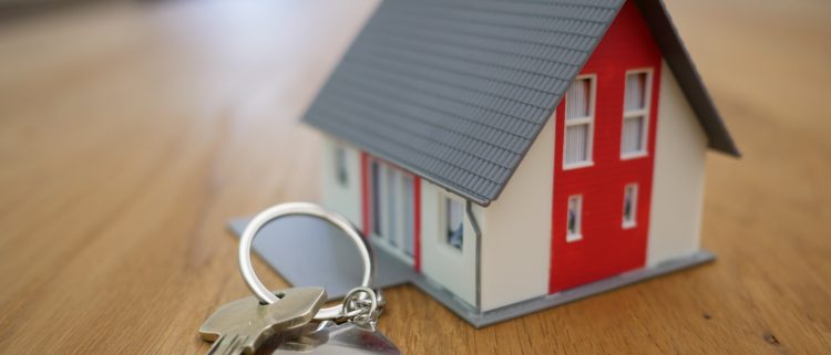 Photo d'une maison miniature avec des clés à côté